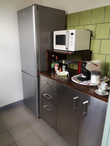 a kitchen with a stainless steel refrigerator and a microwave at Casa Pagiò in Bosa