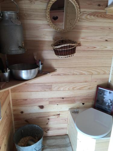 La salle de bains est pourvue d'un mur en bois, de toilettes et d'un lavabo. dans l'établissement Les Chemins de l'osier, à Vachères-en-Quint