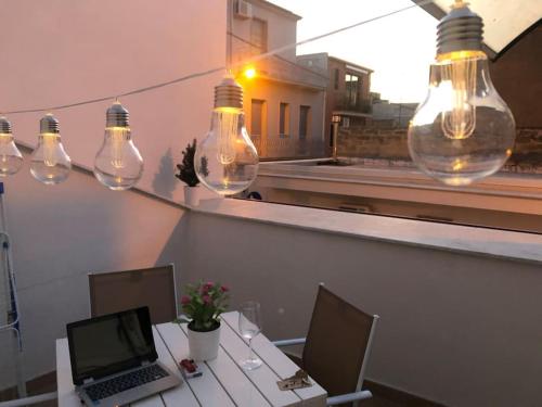 une chambre avec une table, un ordinateur portable et des lumières dans l'établissement Casa Felice, à Comiso