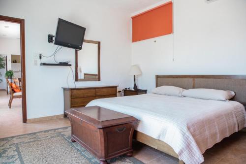 a bedroom with a bed and a flat screen tv at Departamento con alberca privada in Chetumal