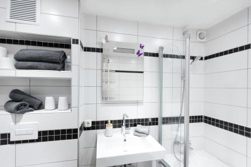 a white bathroom with a sink and a shower at Ferienwohnung Villa Abrioux am Park in Bad Bertrich