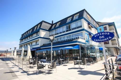 a building with tables and chairs in front of it at Hotel Astuy in Isla