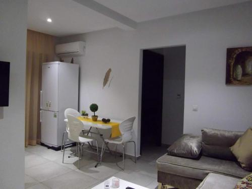 a living room with a table and chairs and a refrigerator at Le lagon de Hammamet in Hammamet
