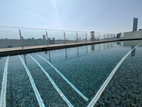 a pool of water with a fence on top of it at Stylish Panoramic Views City Loft in Monterrey