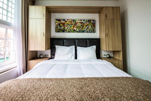 a bedroom with a large bed with a painting above it at Hotel Inn Naeldwyk-Torenburg in Naaldwijk