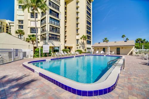 a swimming pool with chairs and a building at Hutchinson Island Vacation Rental with Beach Access! in Fort Pierce