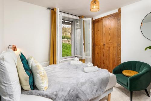 - une chambre avec un lit et une chaise verte dans l'établissement Le Pied à Terre de la Cité - Parking au Pied de la Cité, à Carcassonne