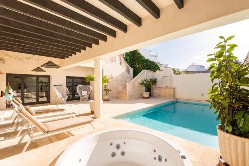 a house with a swimming pool and a bath tub at Sa Capella : Ancienne chapelle rénovée avec piscine in Mahón