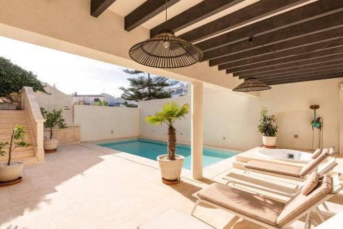 a patio with lounge chairs and a swimming pool at Sa Capella : Ancienne chapelle rénovée avec piscine in Mahón
