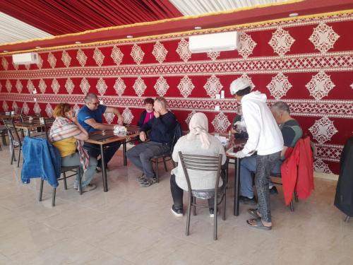 a group of people sitting at tables in a restaurant at Yara camp in Wadi Rum