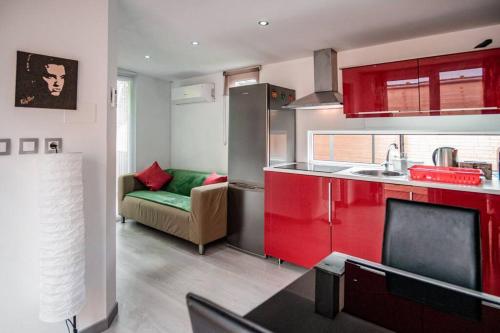 una cucina con armadi rossi e un divano verde di Private Paradise on cozy Campsite, Jacuzzi, Netflix a Las Galletas