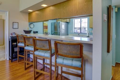 a kitchen with a bar with chairs and a sink at Patio, Grill and Pool Access Palm Desert Retreat! in Palm Desert