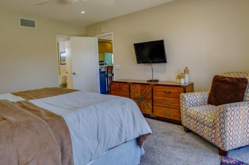 a bedroom with a bed and a tv and a chair at Patio, Grill and Pool Access Palm Desert Retreat! in Palm Desert