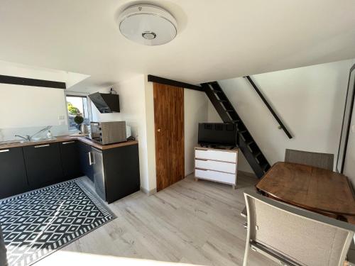 une cuisine et une salle à manger avec une table et un escalier dans l'établissement O Phil d’Or, à Rucqueville