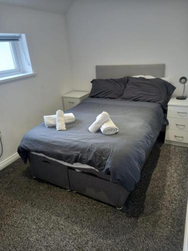 a bed with two towels on it in a bedroom at Modern Apartment with Roof Garden Close to City Centre in Cardiff