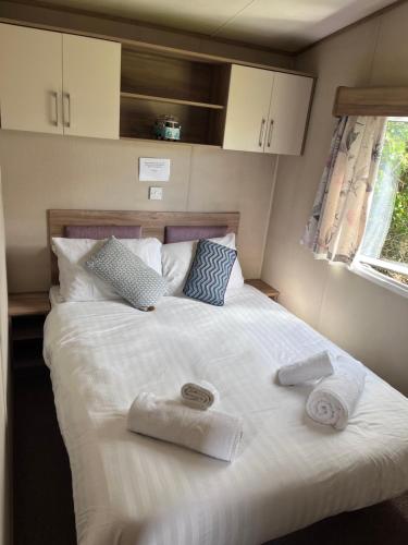 a bedroom with a large white bed with towels on it at Newquay Caravan, Newquay Bay Resort Jetts View 104 in Newquay