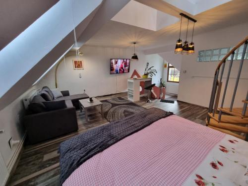 a bedroom with a large bed and a living room at Pension DonauBlick Grein 2 in Stifterstrasse 19A in Grein