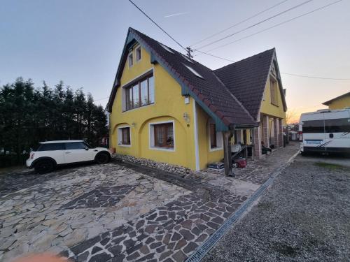 een geel huis met een auto ervoor geparkeerd bij Pension DonauBlick Grein 2 in Stifterstrasse 19A in Grein