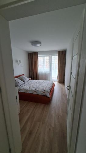 - une chambre avec un lit et une grande fenêtre dans l'établissement Jaukūs namai-Home Sweet Home, à Klaipėda