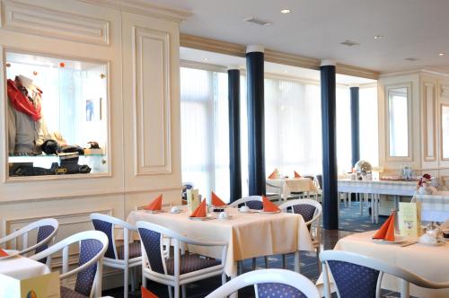 a dining room with tables and chairs and windows at Hotel - Restaurant Erich Rödiger in Bad Staffelstein