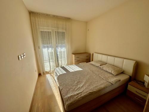 een slaapkamer met een bed en een raam bij Apartmants City Love in Podgorica