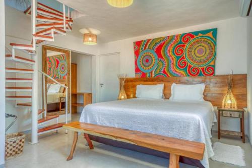 a bedroom with a bed with a bench and a painting at Pousada Rota Ecológica in Pôrto de Pedras