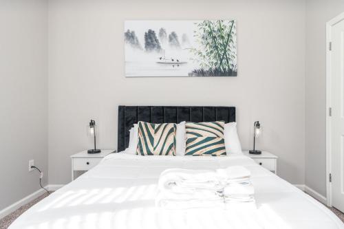 een witte slaapkamer met een groot wit bed met 2 lampen bij Charming 1-BD Retreat Tranquil Zionsville in Whitestown