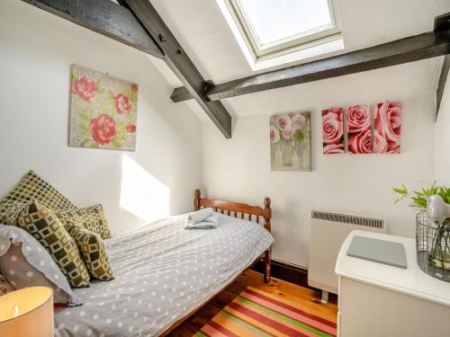 1 dormitorio con 1 cama y algunas flores en la pared en Ty Ysgubor - Jyz, en Gowerton
