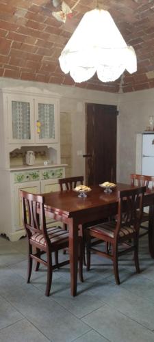 mesa de comedor con sillas y techo blanco en La casa dei limoni, en Olivola