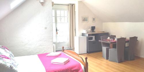 um pequeno quarto com uma cama e uma cozinha em Chambres d hôtes La Cavalière em Accous