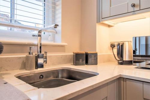 a kitchen with a sink and a window at Luxurious newly built cottage in central Wivenhoe in Wivenhoe