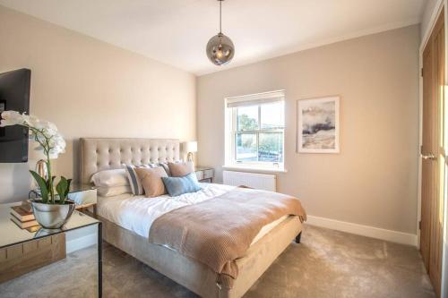 a bedroom with a large bed and a window at Luxurious newly built cottage in central Wivenhoe in Wivenhoe