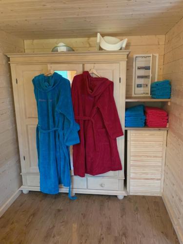 a closet with two red and blue shirts in it at Ferienhaus Spielburg in Altötting