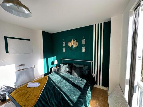 a bedroom with green walls and a bed with a wooden table at Comfortable Private Room in Bermondsey in London