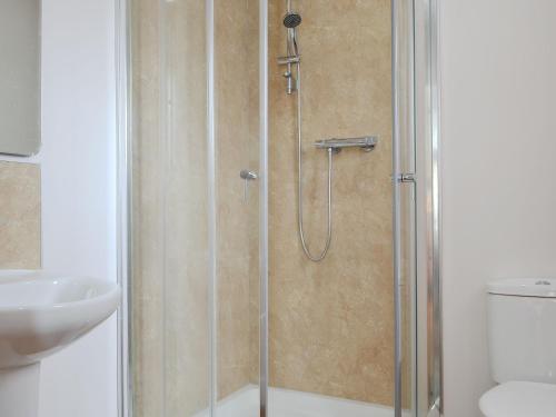 prysznic ze szklanymi drzwiami obok umywalki w obiekcie Ard Meanish w mieście Milovaig