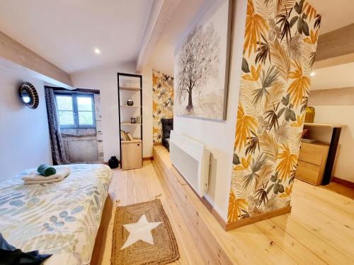 a bedroom with a bed and a wall with a mural at Fleurs de vigne, gîte charentais au grand coeur in Bouteville