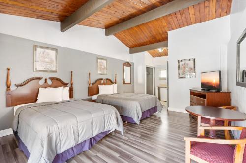 Habitación de hotel con 2 camas y mesa en FairBridge Inn and Suites West Point, en Highland Falls