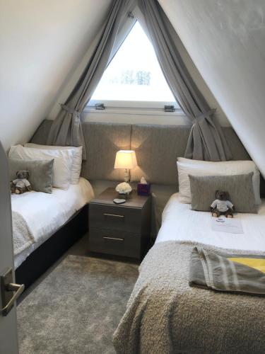 een slaapkamer op zolder met 2 bedden en een raam bij Chalet 47 By The Sea in Kingsdown