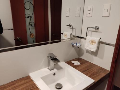 a bathroom with a white sink and a mirror at Hotel Silva Inn in Cajamarca