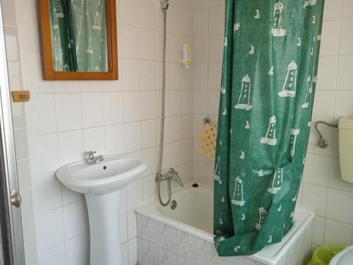a bathroom with a sink and a shower curtain at Canadian Star in Praia de Mira