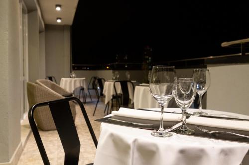 two wine glasses sitting on top of a table at ILLIA 121 APART HOTEL in Neuquén