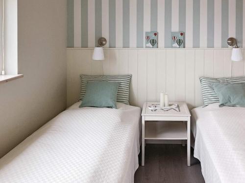 a room with two beds and a table with a candle at Holiday home Skårup Fyn II in Mægård