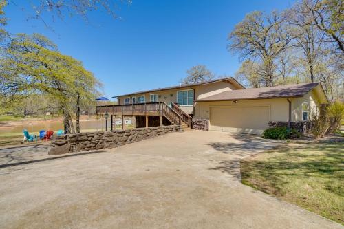 a large house with a garage and a stone wall at Spacious Vacation Rental Home on Eufaula Lake! in Eufaula