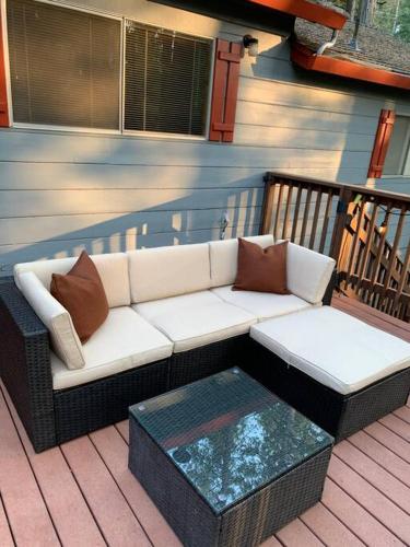 a couch sitting on a porch with a table at Harte's Desire Cabin - Lake, A/C, Arcade + in Twain Harte
