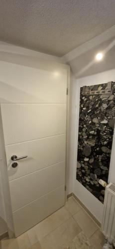 a white door in a room with a rock wall at Ferienwohnung Bergblick in Sebnitz