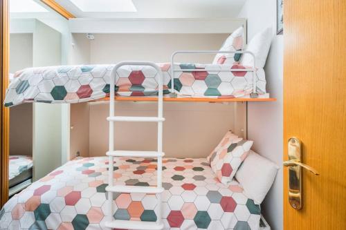 a small bedroom with a bunk bed and a ladder at Dúplex Surf junto a la playa in Miengo