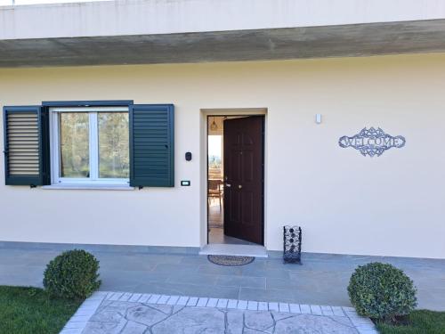 a white house with a brown door and window at La Campagna di Peppe e Tullia in Formia