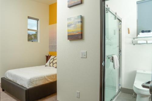 a bathroom with a bed and a glass shower at The Inn at 515 15th in Astoria, Oregon