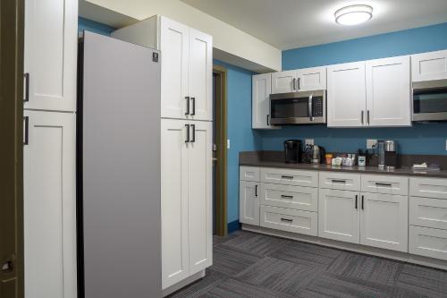 una cucina con armadietti bianchi e frigorifero di The Inn at 515 15th a Astoria, Oregon