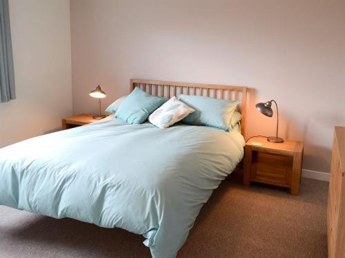 a bedroom with a large bed with blue pillows at Morlich in Gairloch
